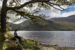 A walker enjoying the peace and quiet at one of the pebble bays on Loch Ba