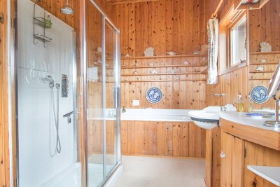 En-suite bathroom with large shower unit and separate bath