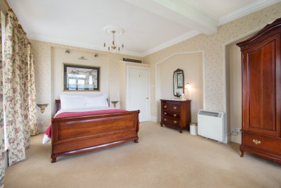 Large double bedroom with king sized bed and luxurious bed linen, towels and robes
