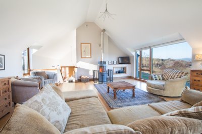 Comfortable seating and wood burning stove with views towards the sea