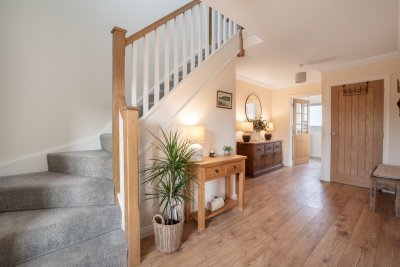 The spacious hallway and staircase rising to the upper two bedrooms and shower rooms