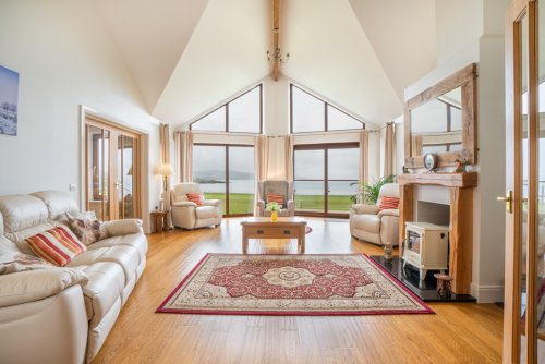 The living room features a vaulted ceiling and fantastic sea views across the airfield