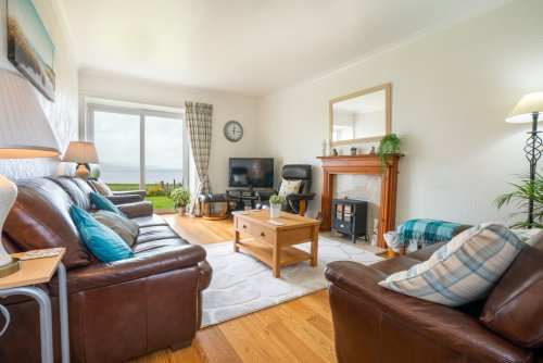 Relax in the spacious living room with stunning sea views at Tigh Bhan