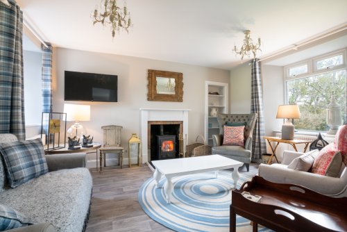 Sunshine or showers, the cosy living room promises the perfect spot to curl up beside the wood burning stove