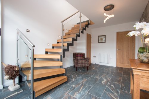Entrance hallway with stairs, leading to bedroom, bathrooms and large utility room