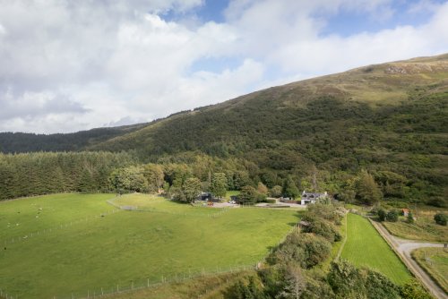 Coorie Doon, separated from Torlochan House by trees, and tucked on the working smallholding